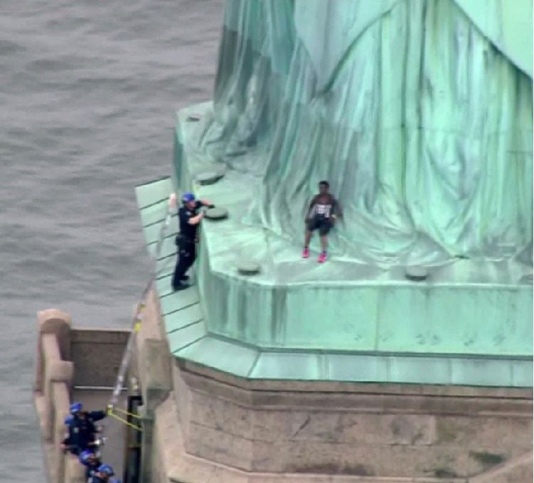 Mujer escala la Estatua de la Libertad en protesta contra Donald Trump