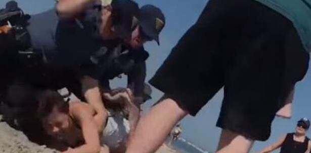 Policía arremete fuertemente contra una joven para someterla en una playa 